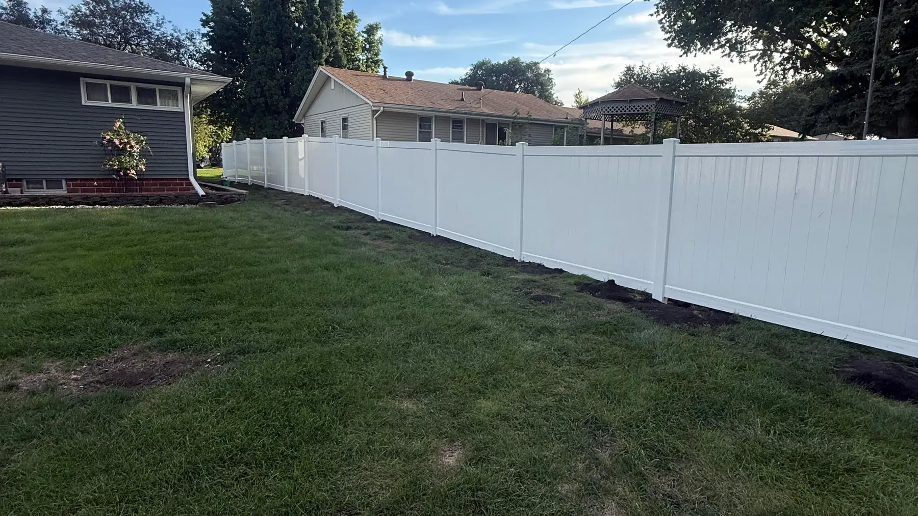 White vinyl privacy fence run built by Precision Fence Co. in the Fort Dodge area